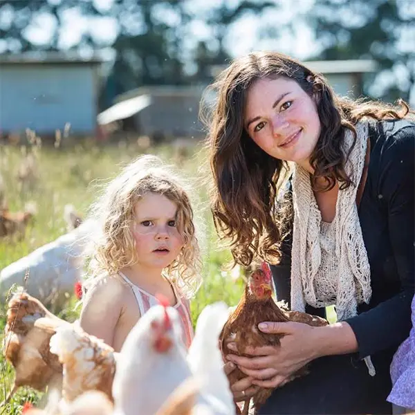 Madelaine with chooks and daughter in their organic farm pasture, at Madelaines Eggs